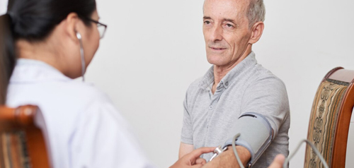 Clinician measuring blood pressure of a male patient