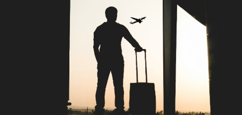 Traveler silhouette with suitcase at an airport